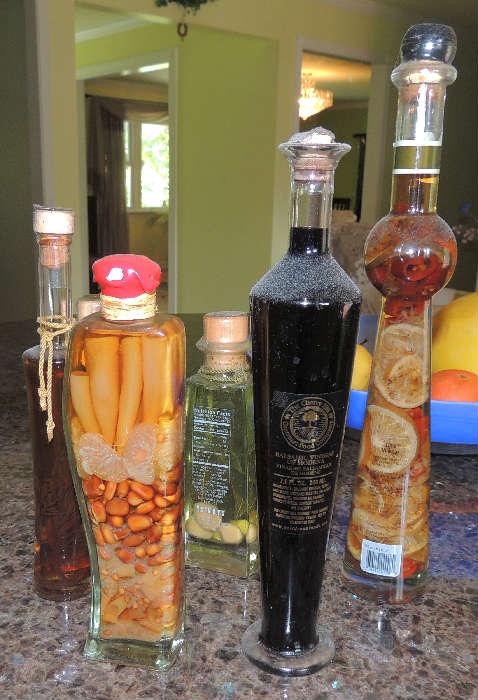Many bottles of fancy infused or flavored vinegar from the kitchen