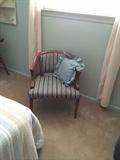 Occasional chair with rattan arms and striped upholstery.