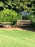 Outdoor garden bench and wheelbarrow used as a planter.