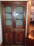 Original etched doors show off this charming cupboard
