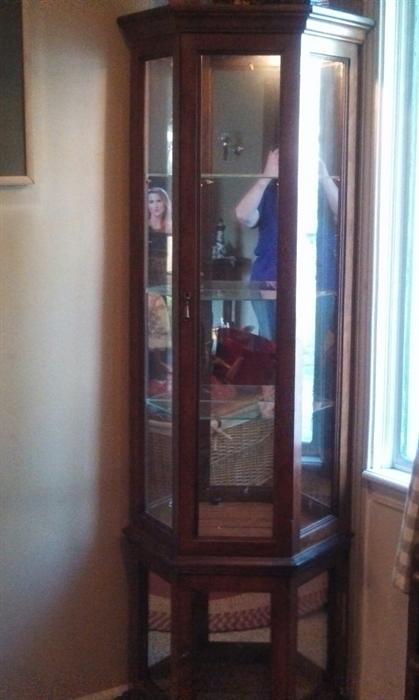 Tall, lighted, curio cabinet.