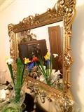 Ornate gold mirror over antique buffet, crystal vase, glass flowers