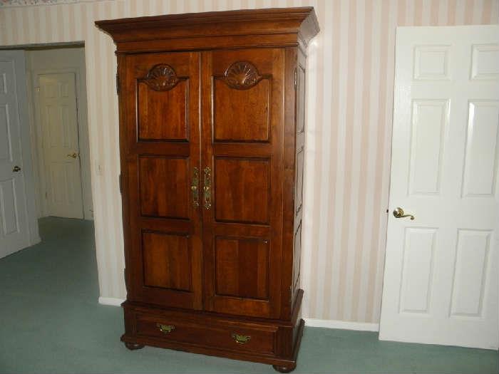 Showing Cherry armoire with paneled doors closed and beautiful brasses.