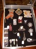 Showcase.  Beaded souvenir items, CZ & gold jewelry, Perfume bottles, Swarovski pr. candleholders, Waterford bird and small clock, Dutch silver scoop, Sterling spoons, etc.
