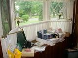 Office items.  Mounted in the bay window are Victorian brass gas brackets with new shades and candles added