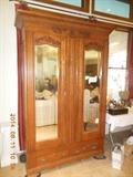Antique armoire wardrobe cabinet with carvings , mirrors and drawers.