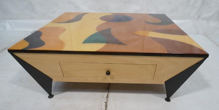 Lot 38  -  Signed Laminated Colorful Wood Table. JAY STANGER style. Modernist swirl design with rich dyed details. Two drawers in beveled sides. Metal corner feet. -- Dimensions:  H: 15.5 inches: W: 41 inches: D: 41 inches --- 