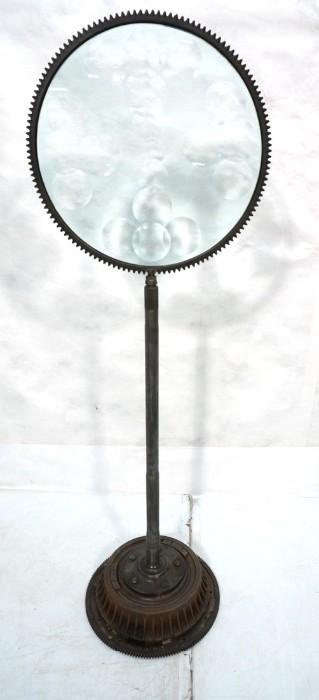 Lot 51  -  Industrial Magiscope Round Sculpture. Engraved Feliciano Bejar. Axle shaft base supports glass round panel. -- Dimensions:  H: 53 inches: W: 17.5 inches: D: 14 inches --- 