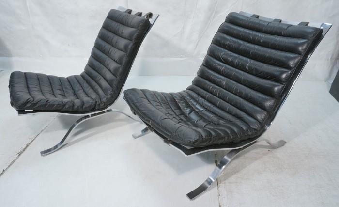 Lot 58  -  Pr Black Leather Lounge Chairs. ARNE NORELL attribution. Wide Stainless Frames. Leather cushion is strapped on frame. Not marked-- Dimensions:  H: 29 inches: W: 26 inches: D: 35 inches --- 