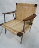 Lot 71  -  Finn Juhl Style Rosewood and Steel Lounge Chair  Large Shaped arms. Steel legs capped with wood that cuts up into leg. Cane seat and back.-- Dimensions:  H: 32.5 inches: W: 30 inches: D: 26 inches --- 