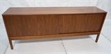 Lot 378  -  Danish Modern Teak Long Sideboard Credenza. Two sliding doors. Beveled edge. Raised on legs. Finished Back. Recessed pulls. Interior fitted with drawers & shelves.-- Dimensions:  H: 31 inches: D: 18.75 inches: L: 79 inches --- 