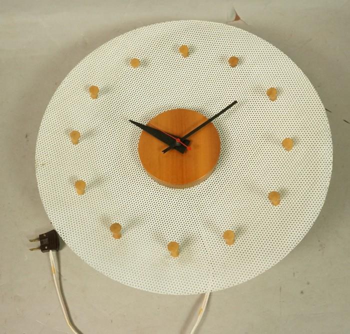 Lot 1  -  GEORGE NELSON Wall Clock. HERMAN MILLER. Circular White Mesh with light wood disc center and pegs. Iconic black metal hands. Howard Miller label. Model #2204.-- Dimensions:  H: 14 inches: W: 14 inches: D: 3.75 inches --- 