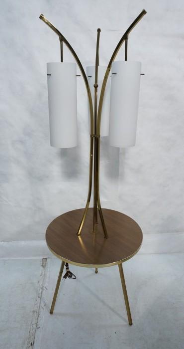 Lot 557  -  Modernist Table Floor Lamp. Gold tone metal with laminate wood grain round table top. Three arms with white glass hanging pendant shades.-- Dimensions:  H: 65 inches: W: 22 inches: D: 22 inches --- 
