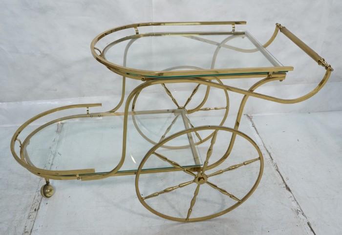 Lot 589  -  Two Tier Brass Rolling Bar Tea Cart. Large rear wheels. Brass gallery trim. Glass shelves. -- Dimensions:  H: 29.5 inches: W: 21.5 inches: D: 49 inches --- 