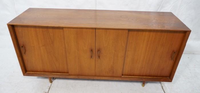 Lot 711  -  Modernist Teak Danish Credenza. Four Sliding Doors. Raised on legs. Metal pulls. Has pull out bar shelf-- Dimensions:  H: 29 inches: W: 69 inches: D: 17.5 inches --- 
