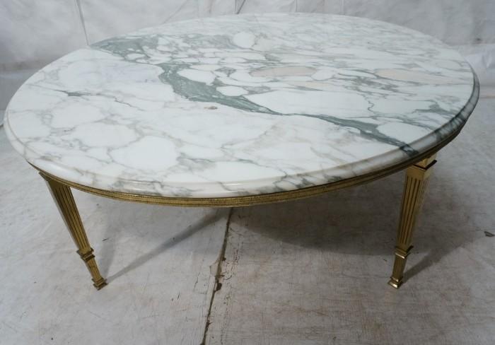 Lot 735  -  Decorator Round Marble Top Cocktail Coffee Table. Metal Fluted Column Legs with metal skirt.  Beveled marble top-- Dimensions:  H: 17.5 inches: W: 46 inches: D: 46 inches --- 