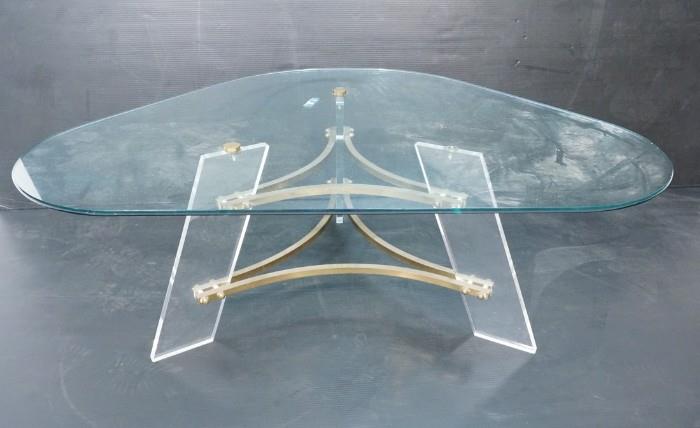 Lot 737  -  70's Modern Lucite & Brass Glass Top Coffee Table. Triangle shaped glass top.-- Dimensions:  H: 16.75 inches: W: 47.25 inches: D: 34 inches --- 