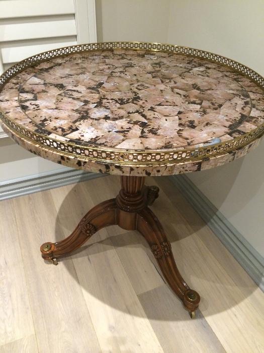 Maitland Smith entry table with mother of pearl inlay and polished bras detailing around the rim.  It could also be used as a large end table next to a sofa.  Paid $6,500 selling it for $1750