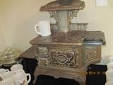 Buck Junior Cast Iron stove That is a regular coffee mug on top to give you an idea of the size.  Could be childs size.  Wonderful condition.