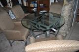 Glass table with 4 high back covered chairs.