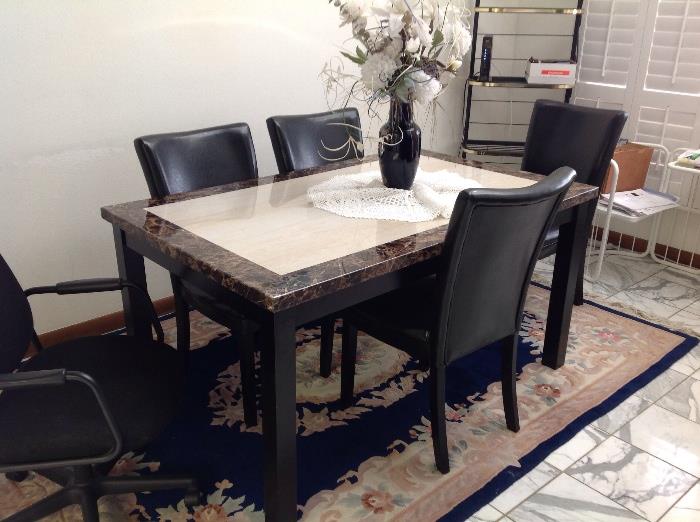 Contemporary stone top dining table and 4 leather chairs, Persian style rug