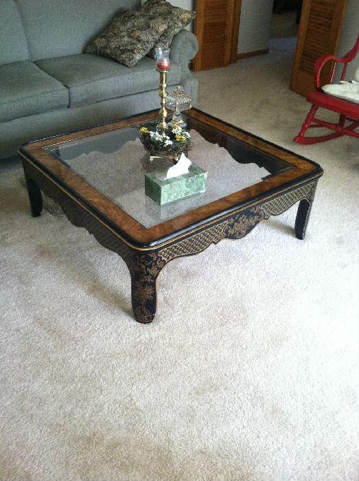 Metal and glass Oriental-style coffee table. Black and gold design with a burled-look finish on top.