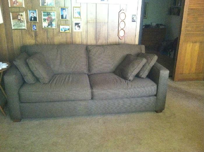 Large, comfy sofa with four throw-pillows.