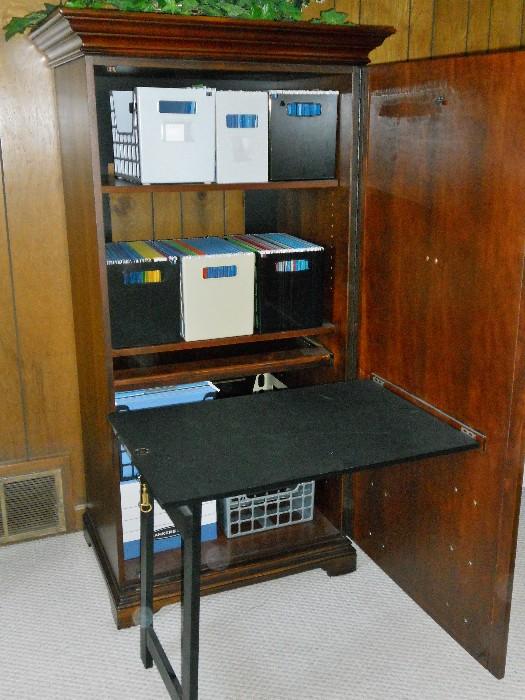Locking Storage Cabinet whose door holds a folded  work desk--has appearance of entertainment cabinet when closed