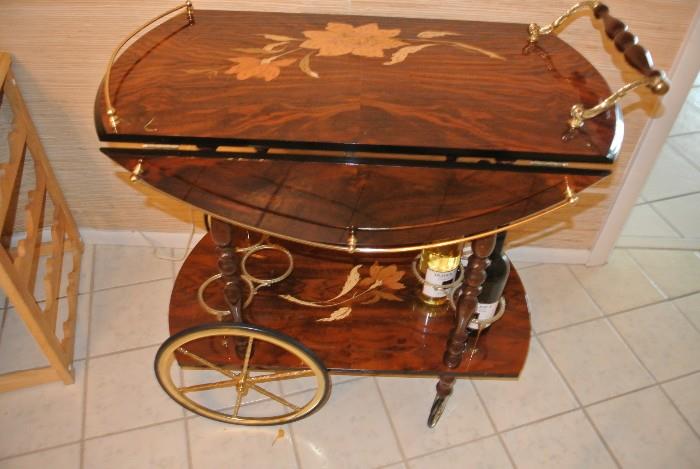Gorgeous Italian parquetry bar cart / tea trolley with brass gallery,
wheels and bottle fittings. Exquisite inlaid marquetry detail.
