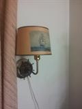 
Very cool nautical sailing ship light to attach to a wall. The decorative "base" is a copper colored ship wheel. The ivory shade shows a wonderful tall ship sailing on blue water, against blue ski.

A charming piece of nautical decor, slightly distressed.

Lamp is in working condition as shown in a photo. The cord needs a bit of cleaning but appears strong. I am not an electrician. Please check carefully before use.
Shade has some surface scratching that adds to the character. These areas of slight scratching may or may not be be able to be cleaned away, if desired. Very charming as is.

Measures app. 11.5" tall , app. 8 1/4 at widest point.
Cord is app. 60" long.
Light bulb not included.