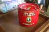 This tobacco tin is full of original tobacco still in the sleeve. 