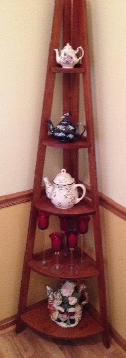 Collection of tea pots including English bone china on graduated corner cabinet shelf