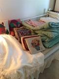 Trundle bed loaded with comforters and needlepoint pillows