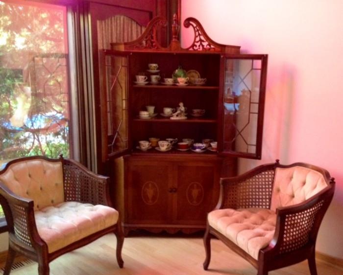 Corner Hutch filled with China & Tea Cups flanked by two cane sided Vintage Chairs