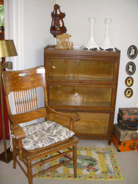3 Section stack barristers bookcase, Oak arm chair with cane seat, Stack of small suitcases, Newer hooked-style rug
