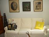 Vintage prints on wall. Slip covered sofa (orange underneath!)