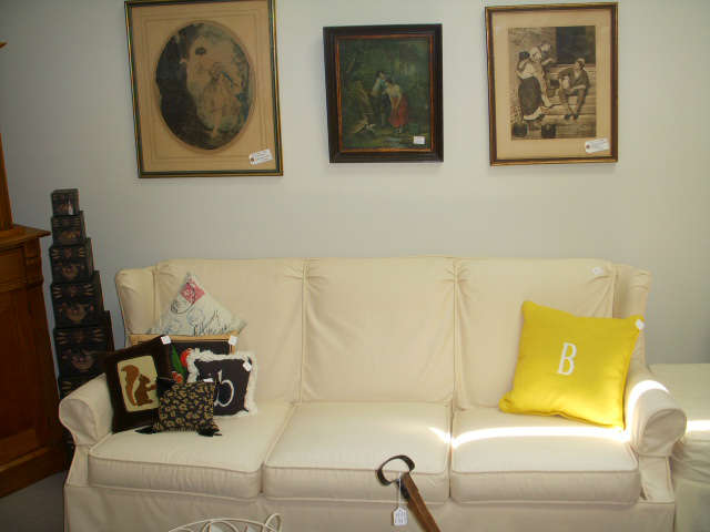 Vintage prints on wall.  Slip covered sofa (orange underneath!)