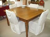 Oak dining table with center (fifth) leg for support. Shown with 2 leaves in, and there are 4 more leaves (2 of those leaves are not original but fit nicely). Chairs are rush seat ladderback chairs that have foam cushions and white slip covers added. Covers can be removed.