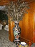Asian floor vase full of peacock feathers.