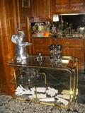 Arthur Court Elephant ice bucket on glass & brass table. Lower shelf displays coral encrusted bottles