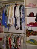 View of clothing in the walk-in closet upstairs. It's a HUGE closet! Clothing ranges in sizes from small to large
