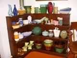 Mahogany corner shelves packed with pottery
