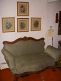 Early 1900 sofa/day bed combination.  Each arm can be raised or lowered as desired.  Needs new upholstery, but works mechanically.  Prints on wall.