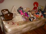 One of two twin beds displaying dolls