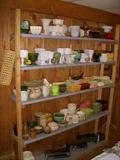 One of two shelving units full of planters (glass & pottery)