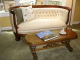 Mahogany curved back sofa with carved details.  Nicely reupholstered.  Vintage coffee table is from the 1920's