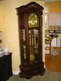 Triple weight Westminster Chime grandfather clock in working order.  Has mirror back and small glass shelves on each side for display