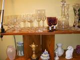 Top shelf (L to R) Sets of stemware, Amethyst stemware set, Cut glass decanter, Pr of outstanding cut glass candlesticks (would make a great wedding gift).  Lower shelf, Pink glass vase, Wedgwood pitcher (chip to spout), Satsuma miniature garden lantern, Dresden lace figurine, Meissen small vase, Irish Belleek vase, Augarten "Wien" cat figurine