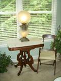 Marble top walnut table, Folding campaign chair, Electrified Gone with the Wind (GWTW) lamp in a frosted grape pattern