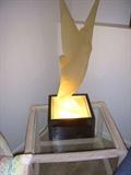 Lucite winged 'goddess' sculpture on lighted base.  Table is a glass top Henry Link wicker/rattan table